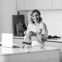 Emily standing at her kitchen table making breakfast.