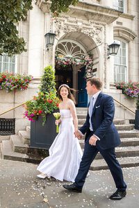 Bride and groom walking in front of church