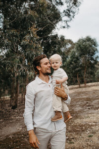 father holding son and walking together in nature