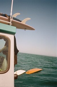 Aesthetic of a vintage surfboard with a vibrant ocean sunset in the background, suggesting timeless coastal vibes