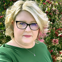 headshot of christina outdoors with flowers in the background
