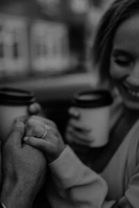 woman holding coffee holding hands with man