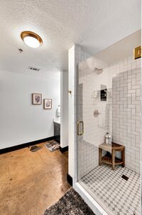 Bathroom with luxurious shower in this two-bedroom, two-bathroom vacation rental condo in the historic Behrens building in downtown Waco, TX just blocks from the Silos, Baylor University, and Spice Street.