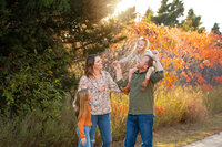 A family poses in front of fall foliage in Oklahoma. Photograph taken by family photographer Missy Mayo.
