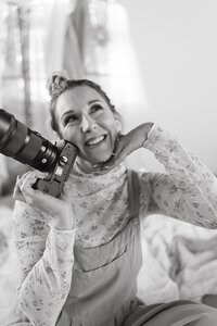 woman holding up camera smiling