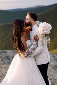Wedding and Elopement Photography, Bride and groom kiss on mountain overlook during Colorado elopement.
