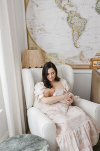 mother cradling newborn daughter in sunlit nursery 