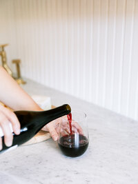 A man pouring wine on a glass