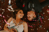 bride & groom laying on floor smiling