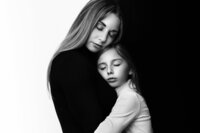 Special Mother and Daughter holding each others faces for mommy and me photos in studio in New Jersey.