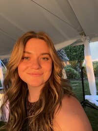a selfie of Katie Graper, Showit Web Designer, during golden hour with a closed lip smile