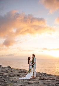 Maui elopement Photographer captures sunset beach wedding when groom kisses bride on forehead