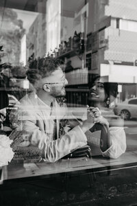 looking through the window at bride and groom smiling together