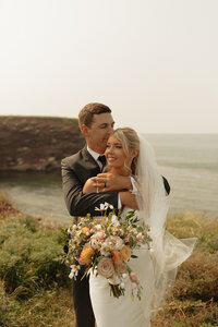 bride and groom embrace on wedding day in pei