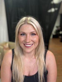 Blonde woman wearing makeup in black tank top