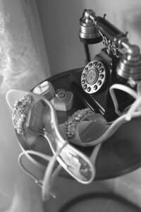 Detail photo of an antique telephone and shoes. 