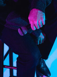 Artistic close-up of a performer’s hand holding a microphone under blue and magenta lights – dynamic brand moment captured by Mewphotovideo