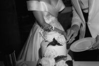 Das Hochzeitspaar wird beim gemeinsamen Anschnitt ihrer Hochzeitstorte gezeigt.