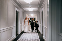 Most Valuable Bridesmaid Day-of Coordinators behind the scenes at New York wedding walking down the hall with Bridal party.