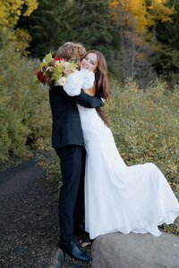 Bride is jumping into the Groom's arms during their elopement in Mt Hood National Forest