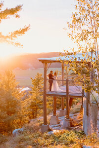 Golden hour wedding portrait of bride and groom on scenic terrace at Le Belvédère wedding venue in Quebec, captured by Ottawa wedding photographer Stacy Kenopic