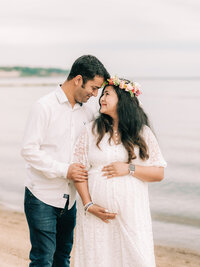 husband and pregnant wife holding baby bump for maternity photos