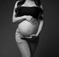 Pregnant couple posing for photo with mom wrapped in sheer cloth.