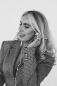 Black and white portrait of Amelia Waters smiling with earbuds in