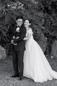 A person standing behind their partner and hugging them on their wedding day 