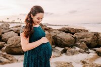 Expecting mother in teal dress on the beach in St. Augustine