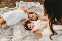 Two little girls cuddling on a blanket captured by Blacksburg, Virginia Family Photographer.