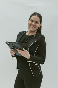 woman smiling while holding an ipad