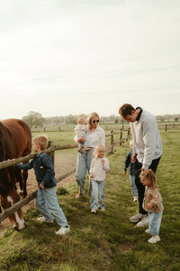 Groot gezin tussen de paarden fotoshoot