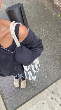 Woman taking selfie of outfit on her way to workout class