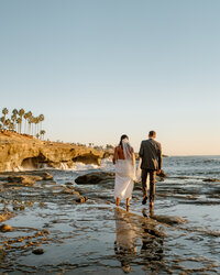 bride and groom on ocean cliff