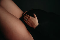 Pregnant woman embracing her belly during a boudoir session in Kansas City