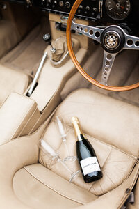 Champagne bottles and flutes on seats of classic car