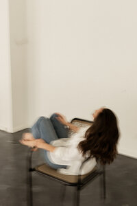 Female SEO consultant sitting sideways in chair