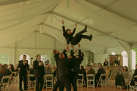 An engaged couple lays in the snow, holding eachother intimately and sharing a gentle kiss