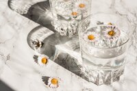 Glasses of water with flowers in them
