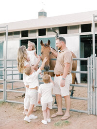 Parents and young children petting a horse