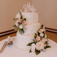 wedding cake with Mr. and Mrs. cake top and light pink roses beautifully designed