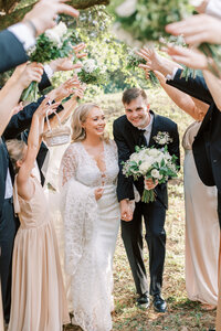 A couple runs through the wedding party.