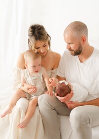Parents and sibling looking at newborn baby taken by Boston Newborn Photographer