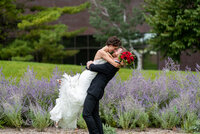 Groom embraces and lifts his bride for a kiss on their wedding day