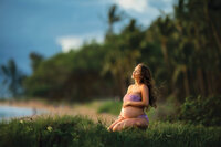 Maternity pictures of eight months pregnant Ivette Ivens from Maui Hawaii at the beach, surrounded by  sand and palm trees, enjoying wind in her hair and fresh air.
