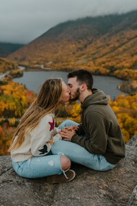 man and woman kissing at new hampshire lake