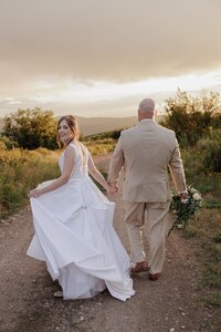 Wedding and Elopement Photography, Bride and groom hold hands during sunset mountain micro wedding photos.