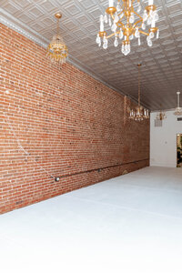 Natural-light photography studio with white walls and brick background in Troy, MO