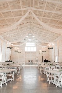 all white wedding barn with drapery and  white farm tables